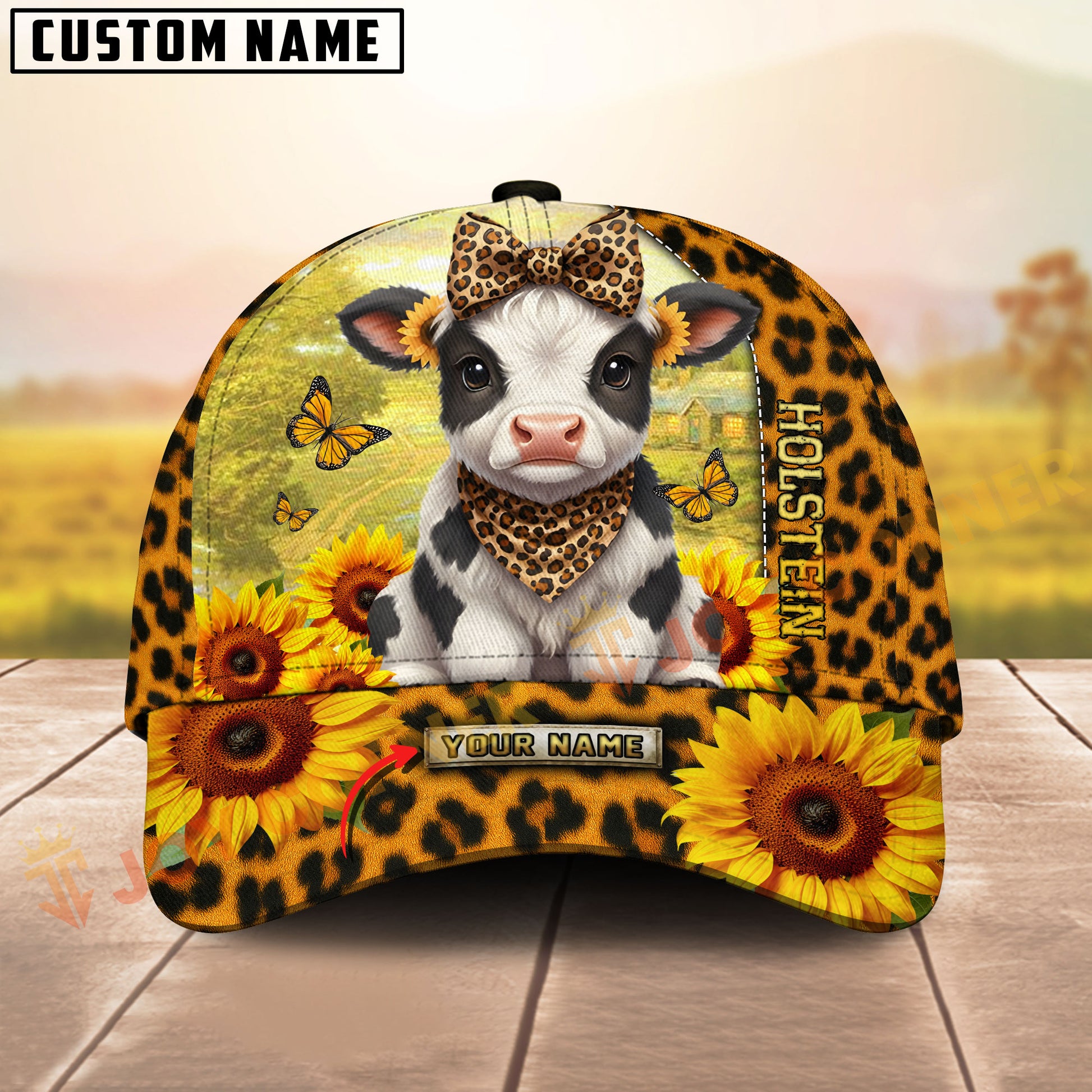 Cow with leopard print bandana and sunflower design on a cap with a blurred outdoor background.