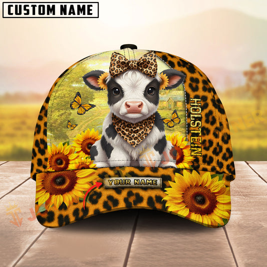 Cow with leopard print bandana and sunflower design on a cap with a blurred outdoor background.