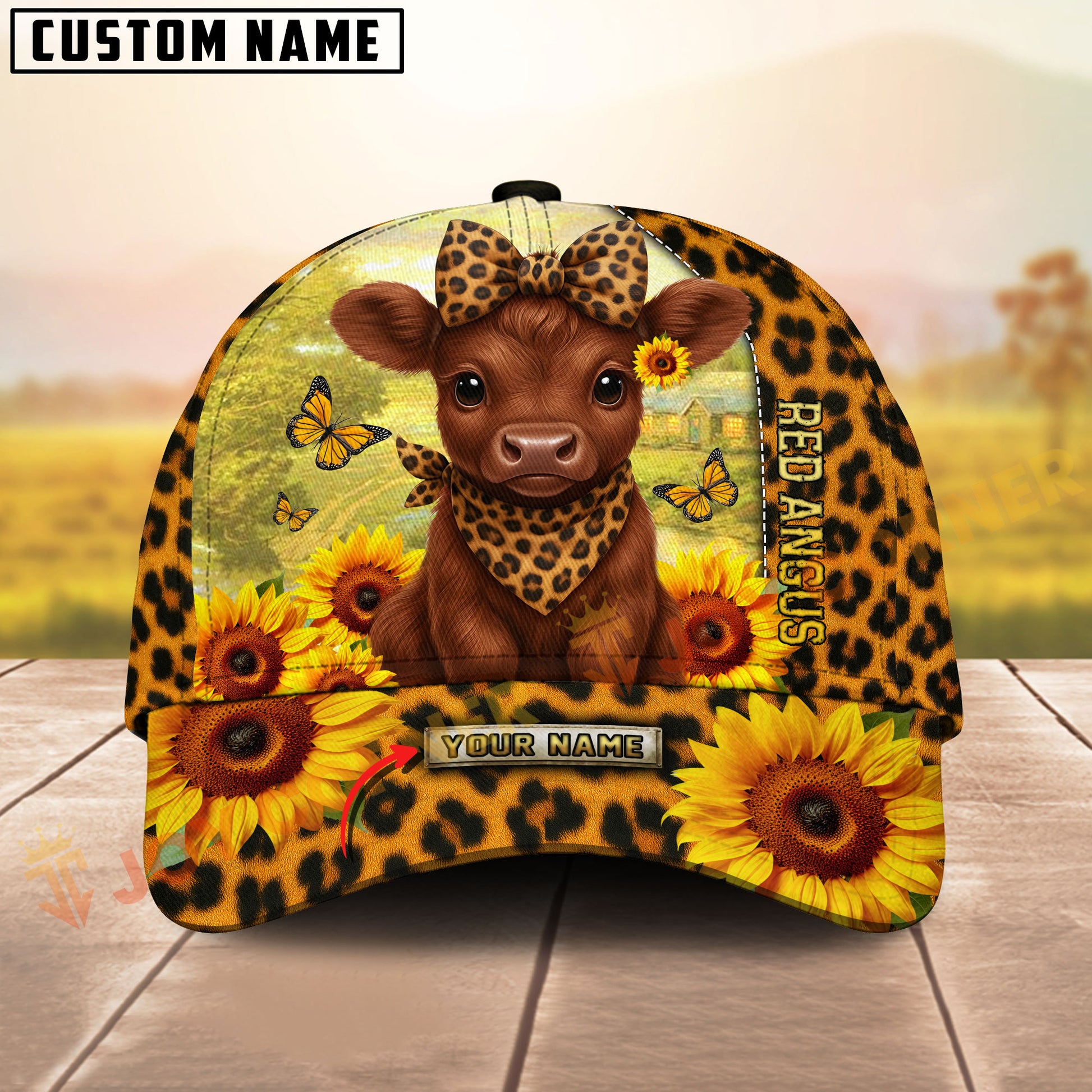 Cap with cow design, sunflowers, and leopard print on a wooden surface with blurred background