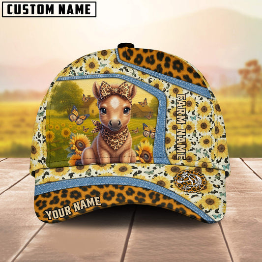Cap with a design of a deer in a field, surrounded by sunflowers and butterflies, on a wooden surface with a blurred natural background.